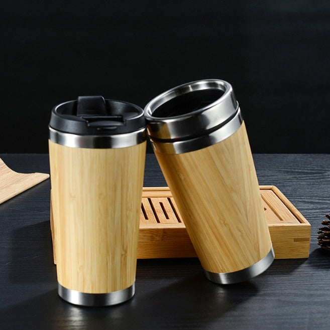Two bamboo-wrapped stainless steel travel mugs with lids.