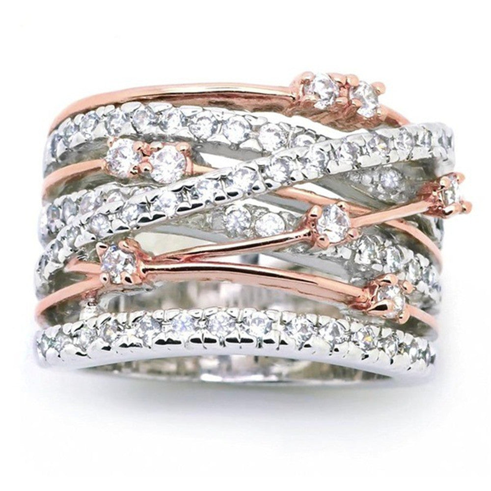 Wide crossover ring with silver, rose gold, and rhinestones.