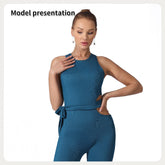 A woman models a teal ribbed jumpsuit with side cutouts and a tie waist.