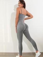 Woman modeling gray textured one-piece spaghetti strap jumpsuit.