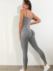 Woman modeling gray textured one-piece spaghetti strap jumpsuit.