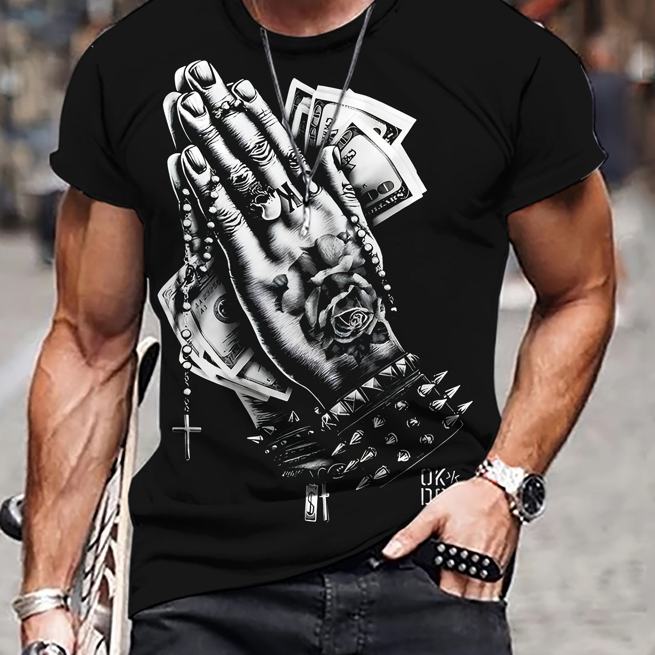 Man in t-shirt with praying hands, money, and rose graphic.