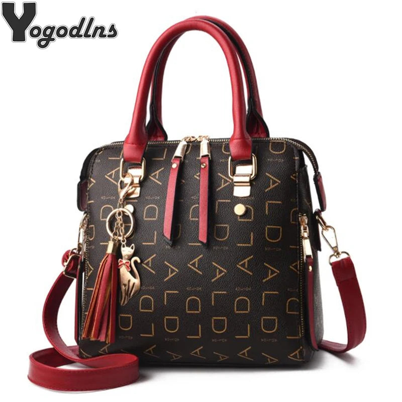 Yogodlns logo handbag with brown print, red handles, and tassel.