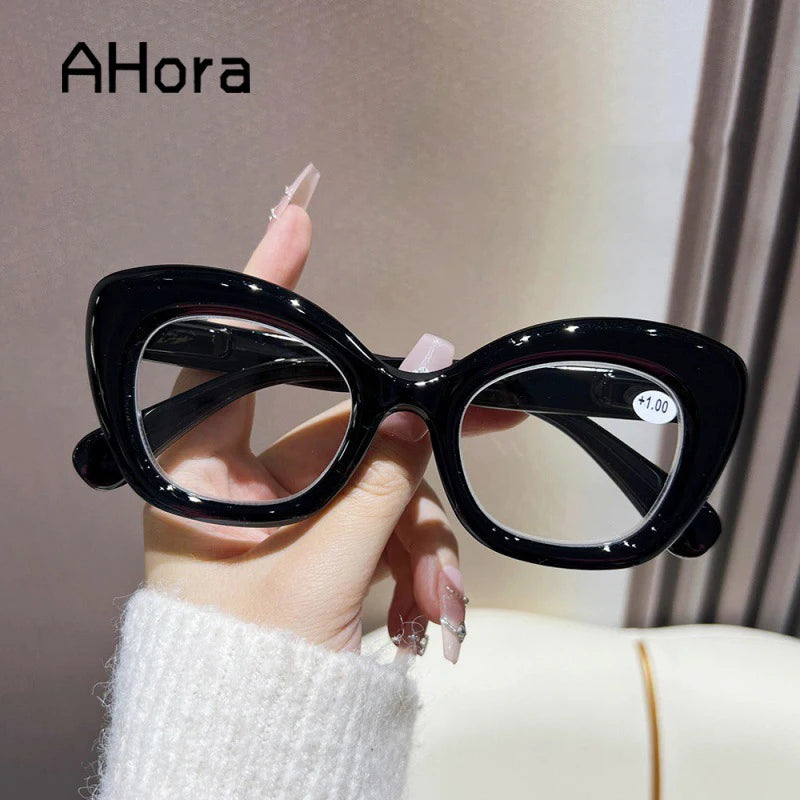 Hand holding black vintage cat-eye reading glasses