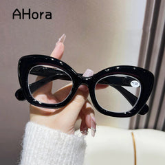 Hand holding black vintage cat-eye reading glasses