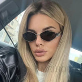 Blonde woman wearing hexagonal sunglasses with metal frame.
