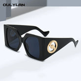 Black angular oversized sunglasses with gold side logo.
