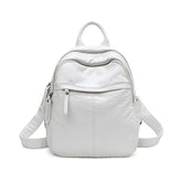 Front view of a small white faux leather backpack.