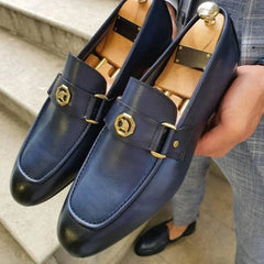 Blue leather men's loafers with black cap toe and gold buckle.