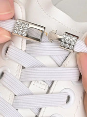 Rhinestone metal buckle clasp on white elastic shoelaces.