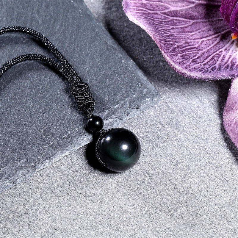 Black braided rope necklace with round black obsidian pendant.