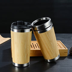 Two bamboo-wrapped stainless steel travel mugs with lids.