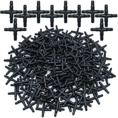 A large pile of black plastic four-way drip irrigation connectors.