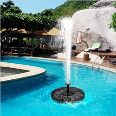 A round black solar water fountain floating in blue water with a jet of water spraying up.