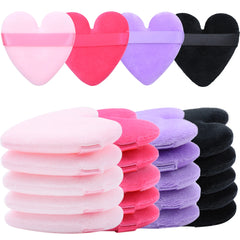 Stack of heart-shaped makeup puffs in pink, magenta, purple, and black.